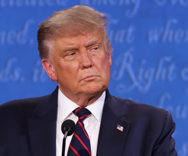 trump at the debate in a suit and striped red and blue tie