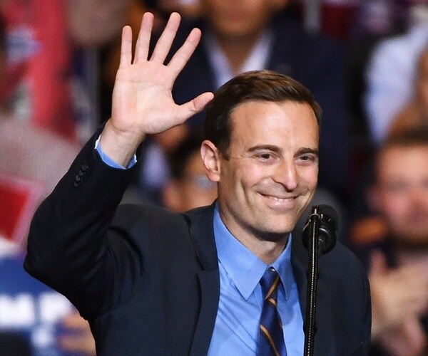 adam laxalt waves while center of the attention at a las vegas campaign rally