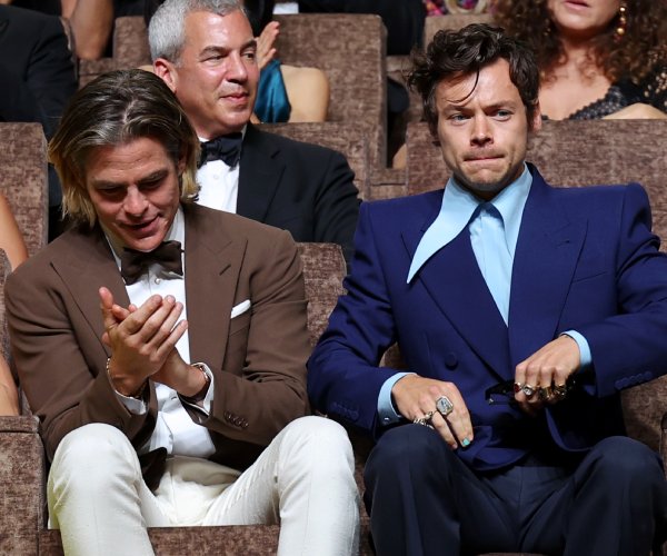 chris pine and harry styles sit at an event