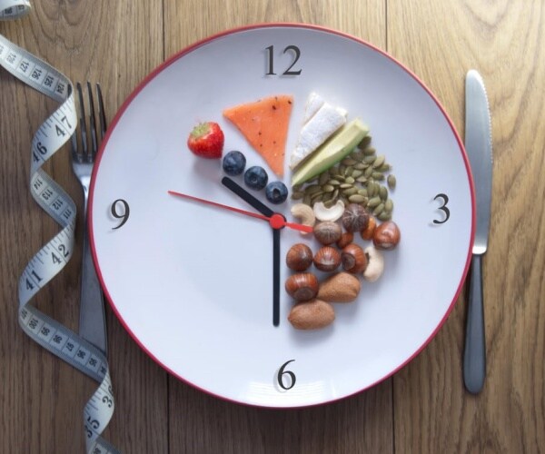 clock with food on it for certain duration indicating time-restricted eating