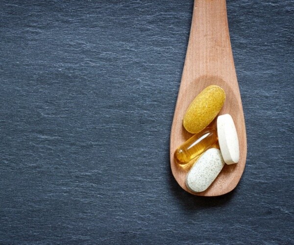 wood spoon with supplements on it