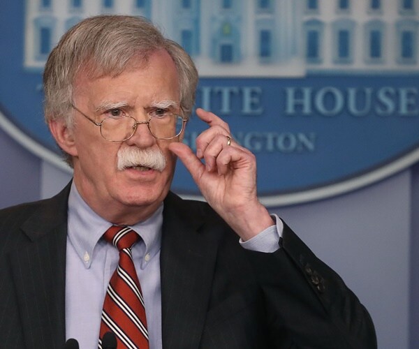 john bolton speaks to reporters in the white house briefing room and adjusts his glasses