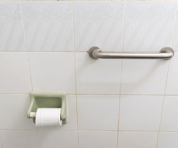 bathroom toilet with grab handle on wall