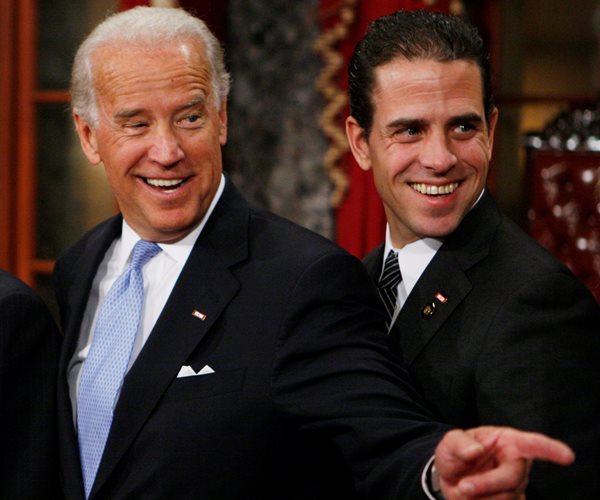 hunter biden and joe biden wearing a blue tie and black suits smiling at a ceremony