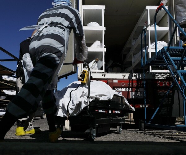 inmates load bodies into refrigerated truck