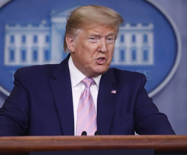 president donald trump speaking at podium in white house press briefing room