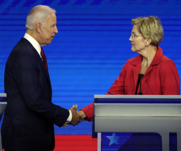 joe biden, left, in dark suit and elizabeth warren, in red jacket and black blouse, shake hands 