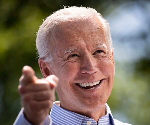 joe biden smiles and points to the camera