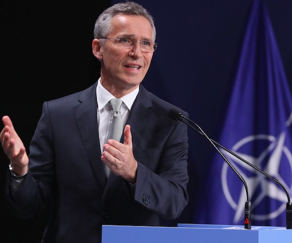 jens stoltenberg gestures as he delivers remarks on stage