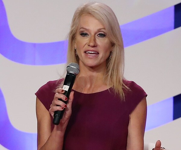 kellyanne conway speaks seated on a state with a mic in her hand