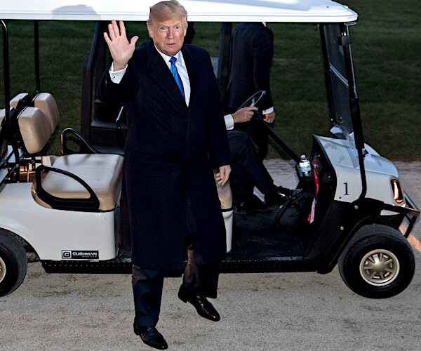 president donald trump waves as he gets out of a golf cart