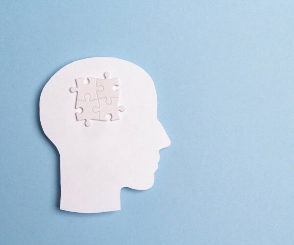 illustration of head with puzzle piece in brain