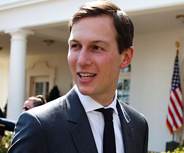 jared kushner looks back over his right shoulder and smiles outside the white house