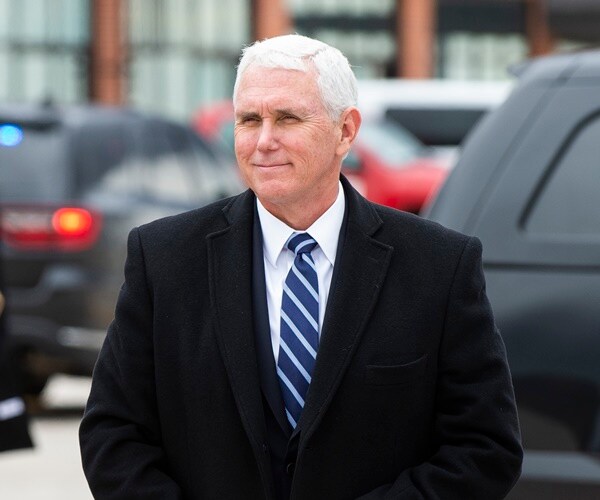 mike pence wearing an overcoat walks on the tarmac