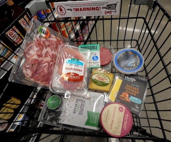 grocery store cart with many different products wrapped in plastic