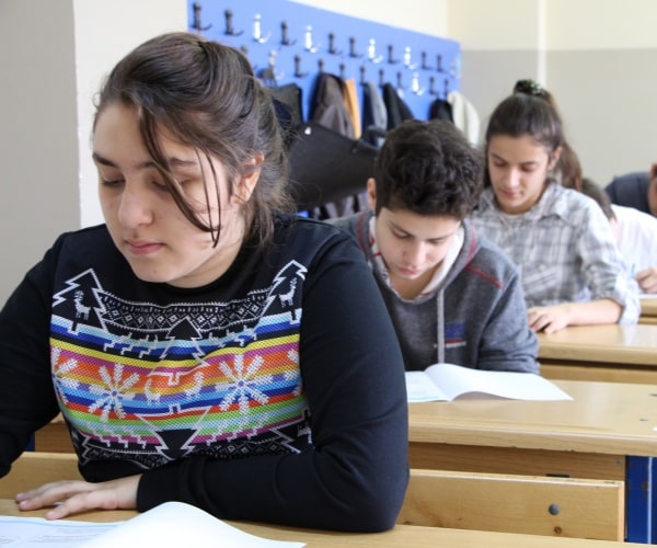 high school students sit in desks and take a test