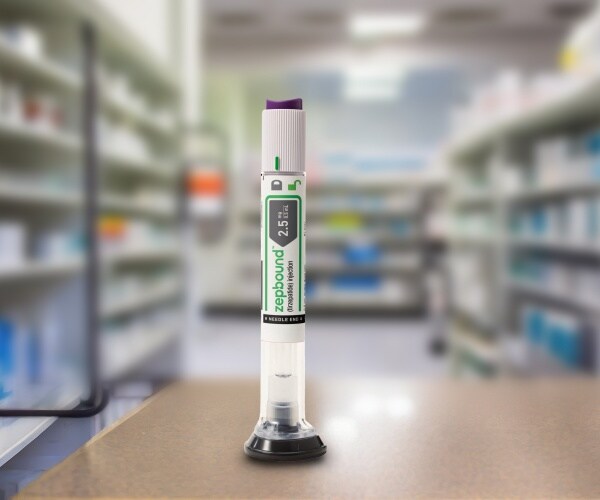 zepbound injection pen in foreground of a pharmacy with shelves of drugs in background